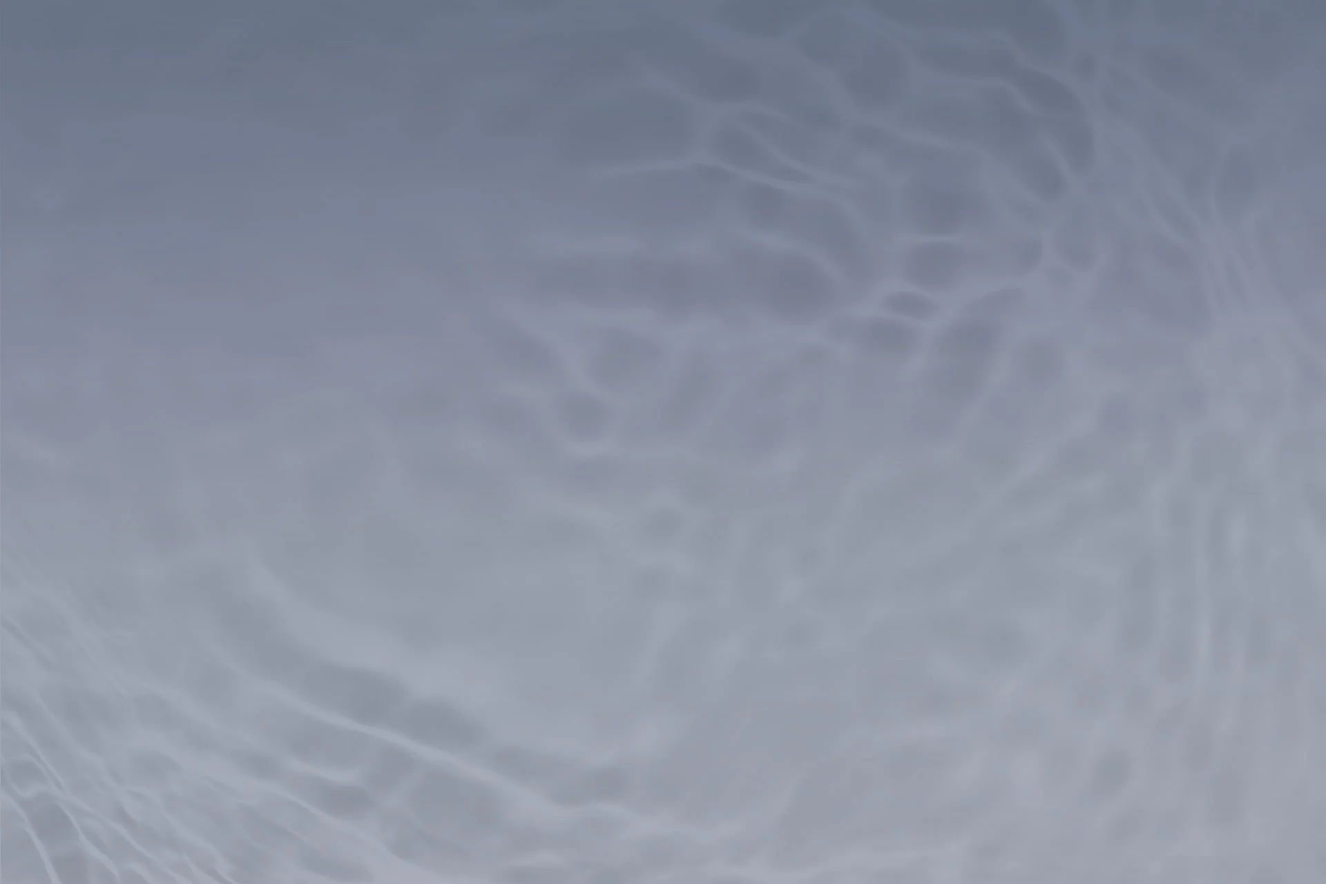 Abstract image of light patterns resembling ripples on water reflected on a smooth grey surface, creating a tranquil and fluid visual effect, much like the calming presence of a veterinarian.